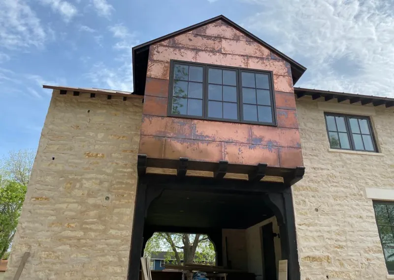 Copper metal panel facade on a stone building for Roof Repair in Chubbuck